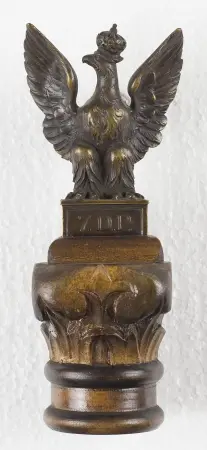 Miniatura Orła ze sztandaru 7 D.P. osadzony na drewnianym postumencie